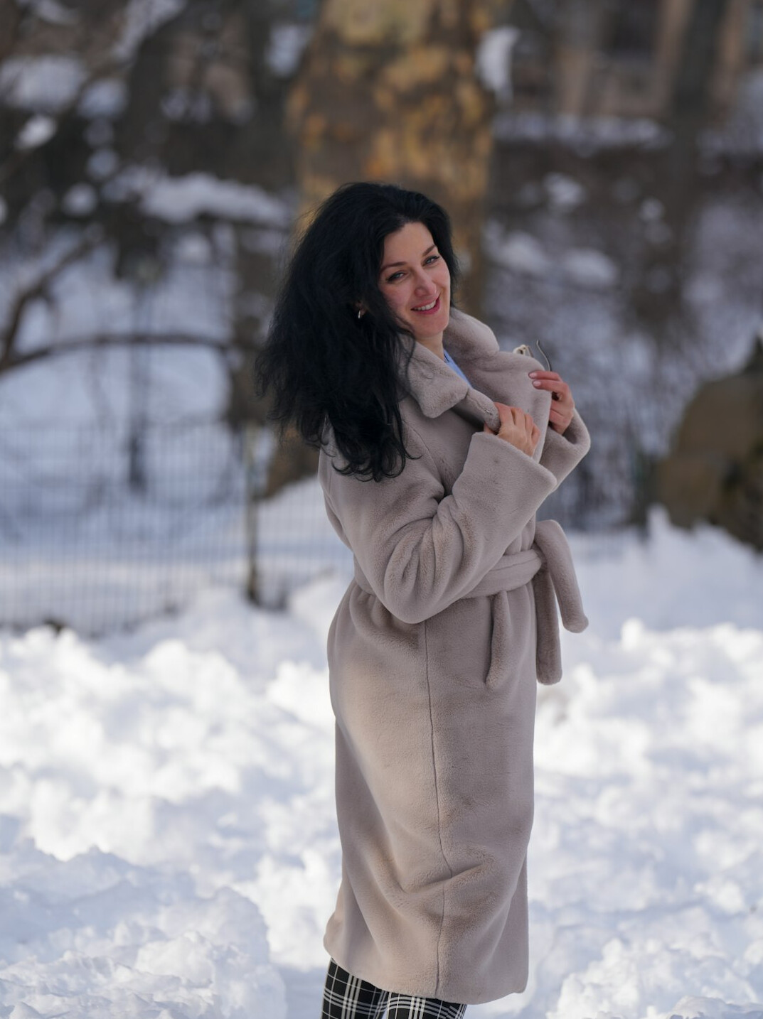 Smiling woman with curly dark hair in a bright setting
