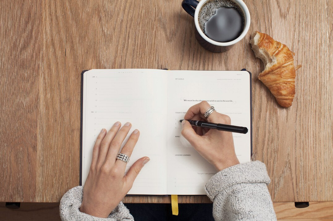 woman writing financial goals in journal
