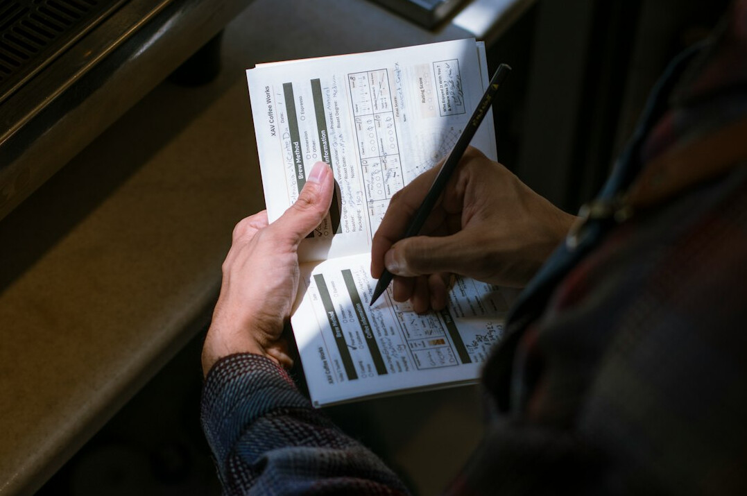 person tracking expenses in notebook