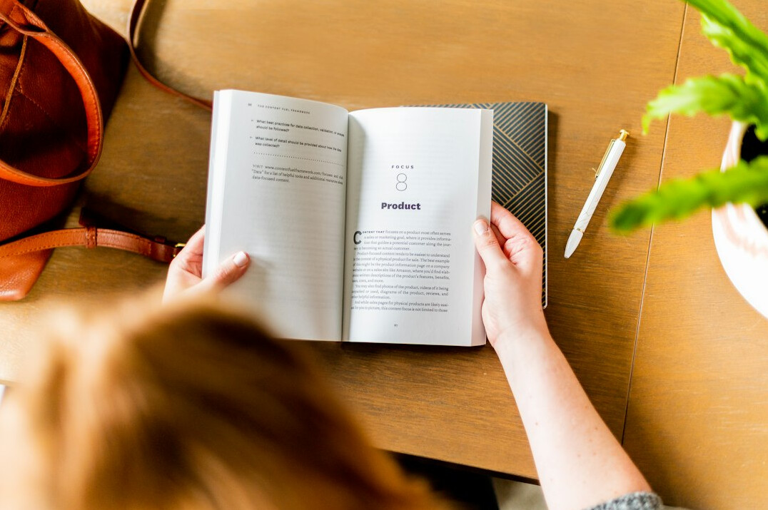 person reading finance book at desk